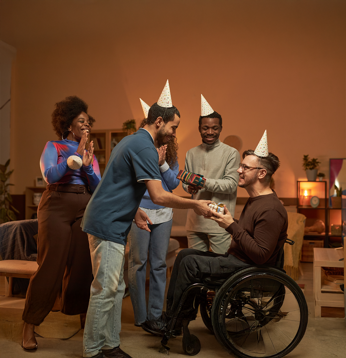 Group of people celebrating with party hats in a living room.
