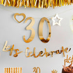 A customisable party banner with gold foil writing and a phrase saying "Let's celebrate"