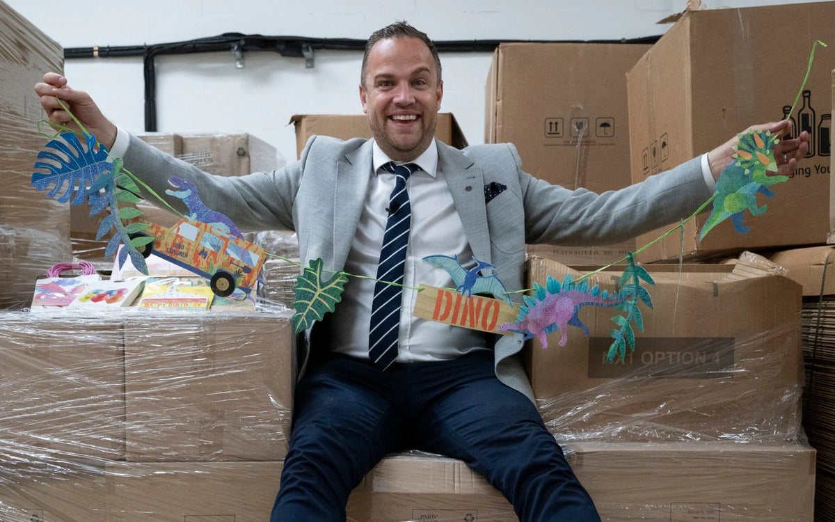 James Sinclair sat on Boxes holding dinosaur part goods