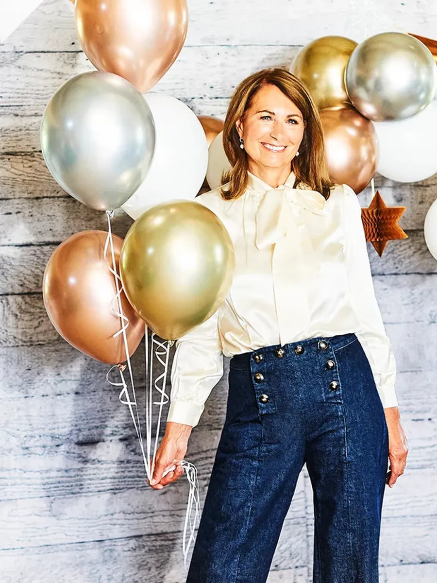 Woman holding balloons against a wooden wall