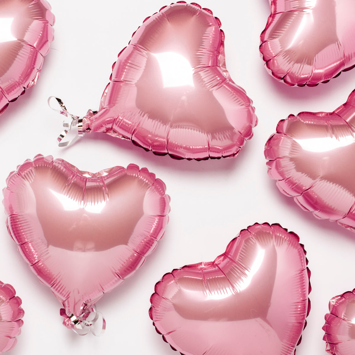 Pink heart-shaped balloons on a white background