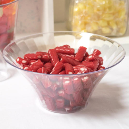 A large transparent plastic party bowl filled with red sweets