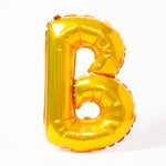A shiny metallic gold letter "B" balloon