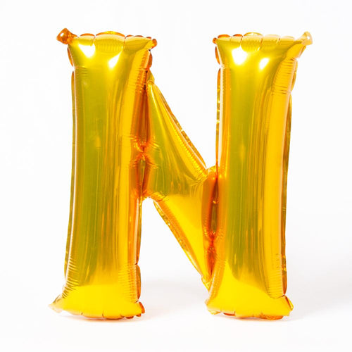 A shiny metallic gold letter "N" balloon