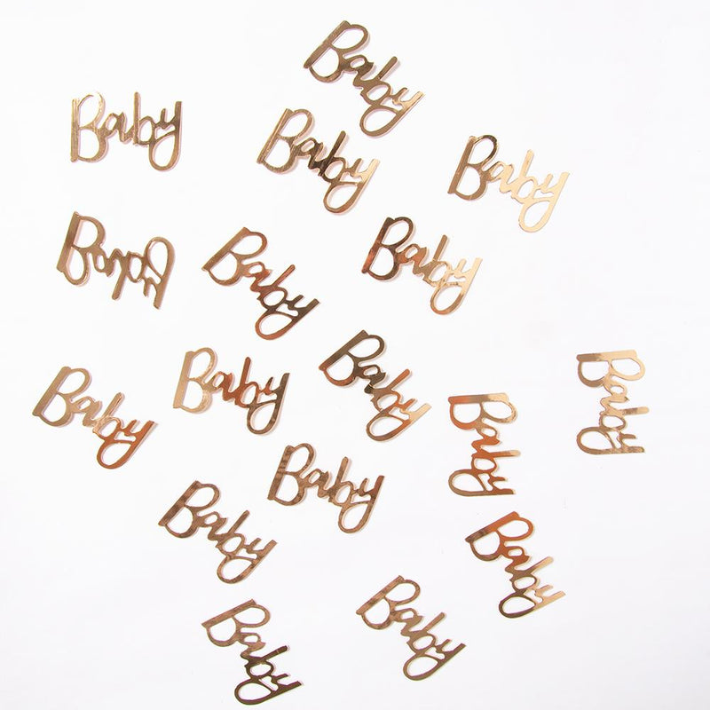 Gold foil baby shower confetti placed on a white background