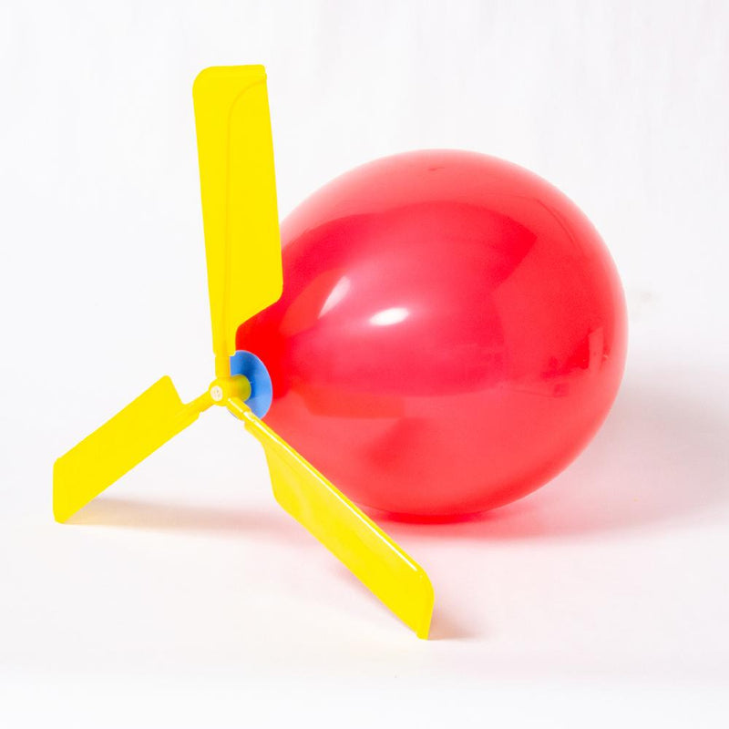 A red party balloon with a yellow balloon helicopter attached to the top