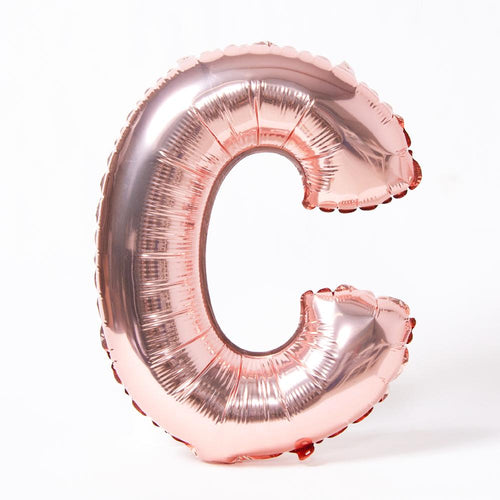 A rose gold foil balloon in the shape of the letter "C"