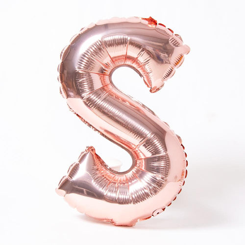 A rose gold foil balloon in the shape of the letter "S"