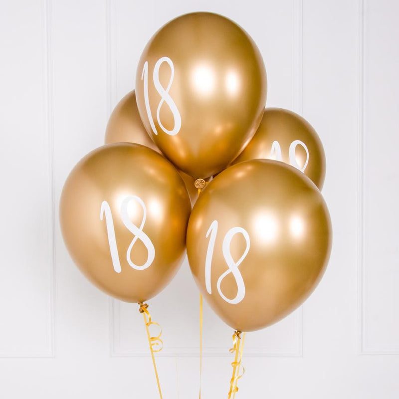 A bunch of metallic gold latex milestone party balloons with a number "18" on it