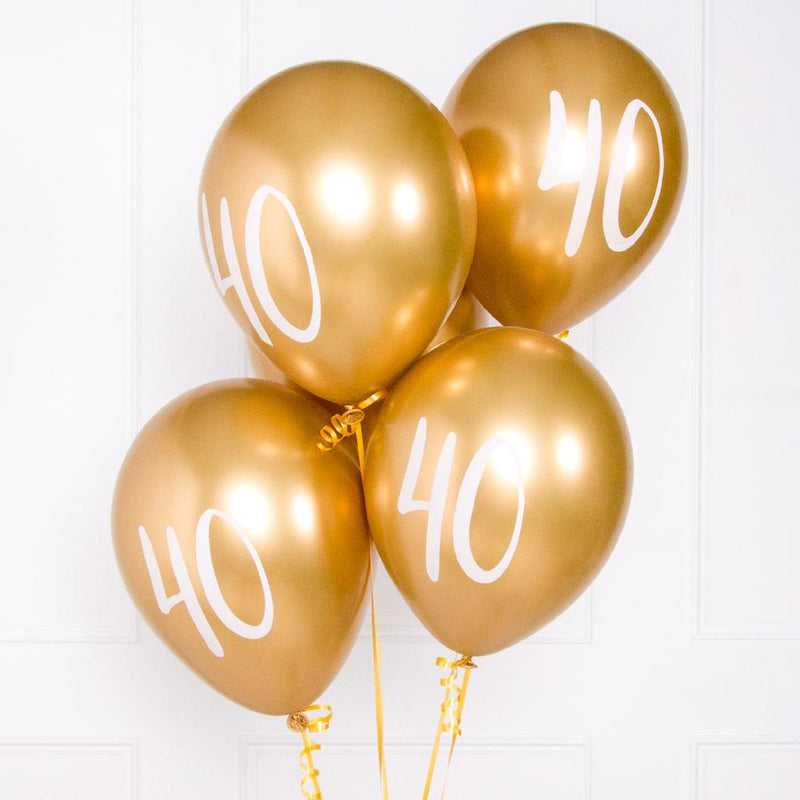 A bunch of metallic gold latex milestone party balloons with a number "40" on it