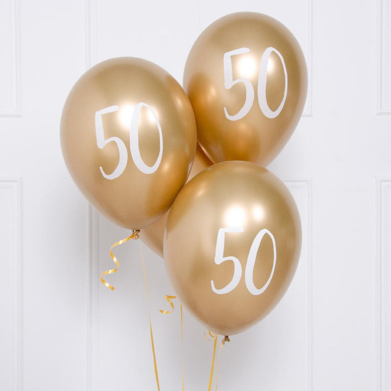 A bunch of metallic gold latex milestone party balloons with a number "50" on it