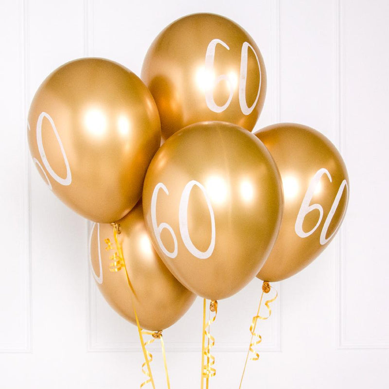 A bunch of metallic gold latex milestone party balloons with a number "60" on it