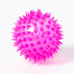 A clear pink bouncy rubber ball with squidgy spines